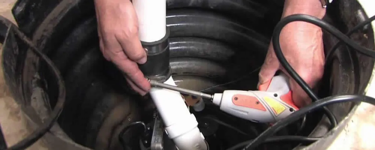 Sump pump installation technician connecting PVC discharge piping in Baltimore, MD